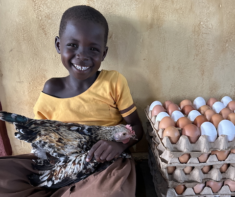 Smiling child holding a basket of fresh eggs